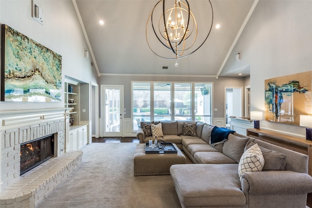 living room with high vaulted ceiling, a fireplace, ornamental molding, a notable chandelier, and built in shelves