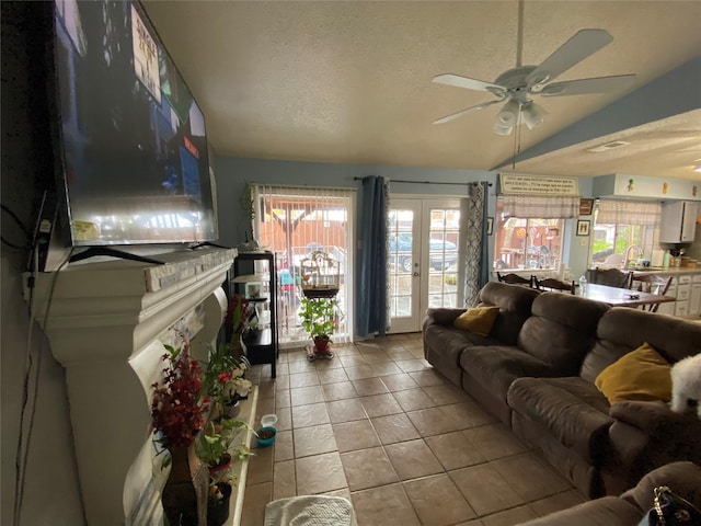 living room with light tile patterned flooring, a healthy amount of sunlight, vaulted ceiling, and a textured ceiling