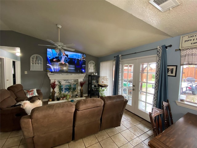 living room with lofted ceiling, light tile patterned floors, french doors, and a textured ceiling