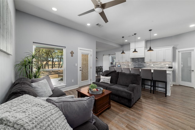 living room with wood-type flooring and ceiling fan