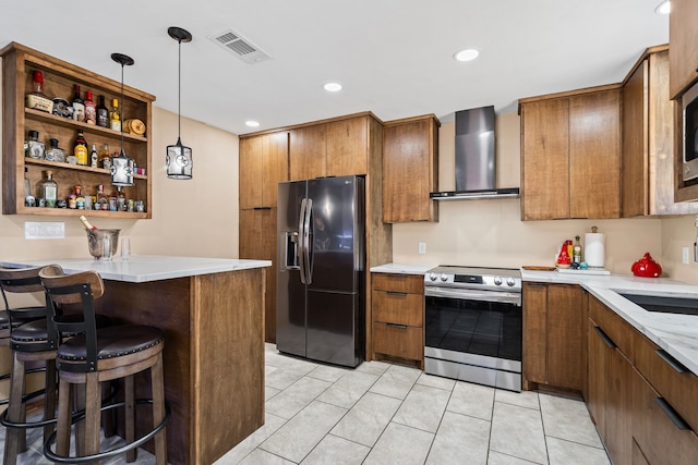 kitchen with appliances with stainless steel finishes, pendant lighting, a kitchen breakfast bar, kitchen peninsula, and wall chimney exhaust hood