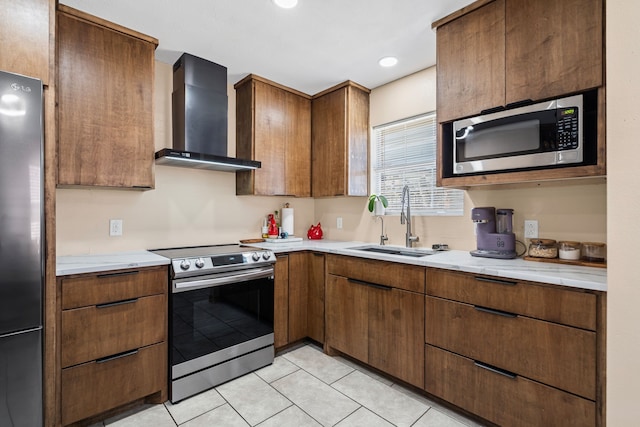 kitchen featuring stainless steel appliances, light tile patterned flooring, sink, and wall chimney range hood