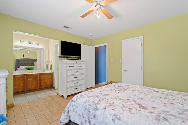 bedroom with ceiling fan, ensuite bathroom, and light hardwood / wood-style flooring