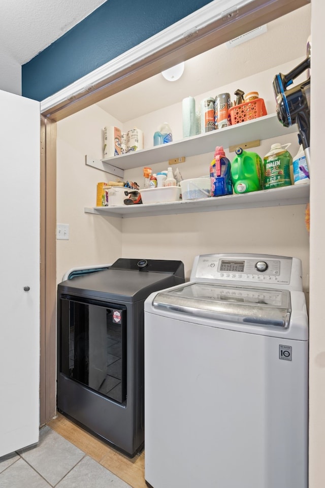 laundry room featuring light tile patterned floors and washing machine and clothes dryer