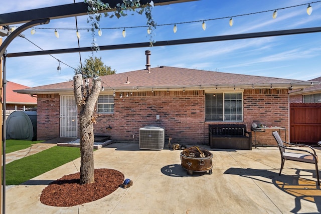 rear view of property with cooling unit, an outdoor fire pit, and a patio area