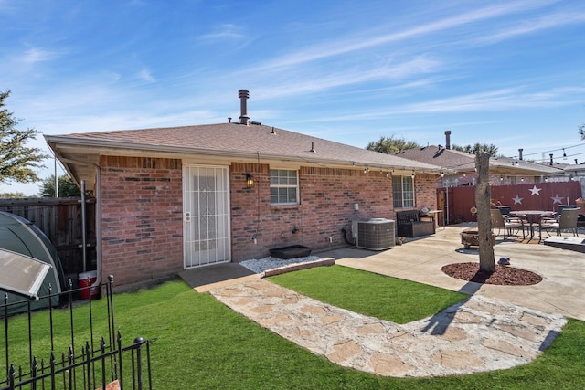 back of house featuring central AC unit, a yard, and a patio area