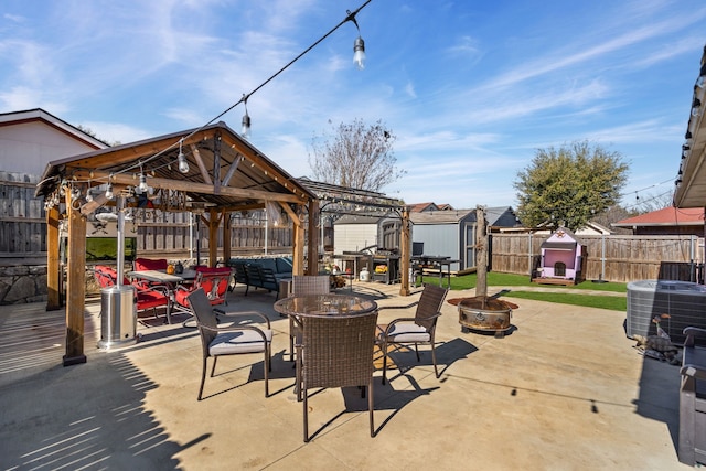 view of patio featuring a storage unit, central air condition unit, an outdoor fire pit, a pergola, and a gazebo