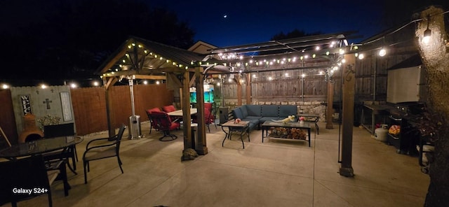 patio at night featuring a gazebo and an outdoor living space