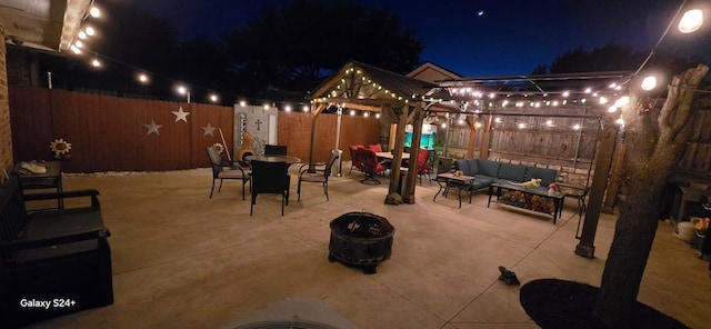 patio at twilight with a gazebo and an outdoor living space with a fire pit