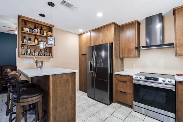 kitchen featuring wall chimney exhaust hood, black refrigerator with ice dispenser, electric range, a kitchen breakfast bar, and kitchen peninsula