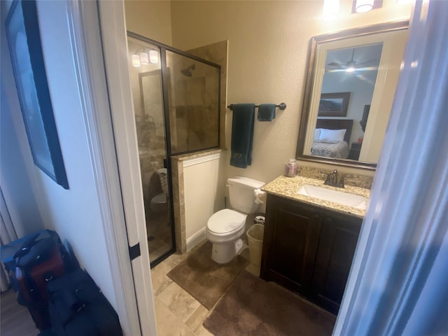 bathroom with vanity, toilet, and a shower with door