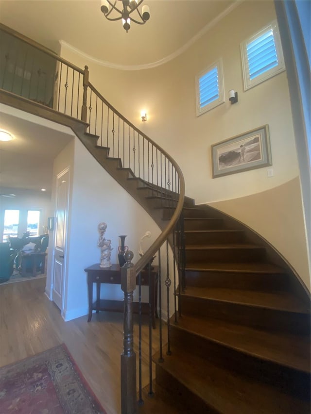 staircase featuring ornamental molding and hardwood / wood-style floors