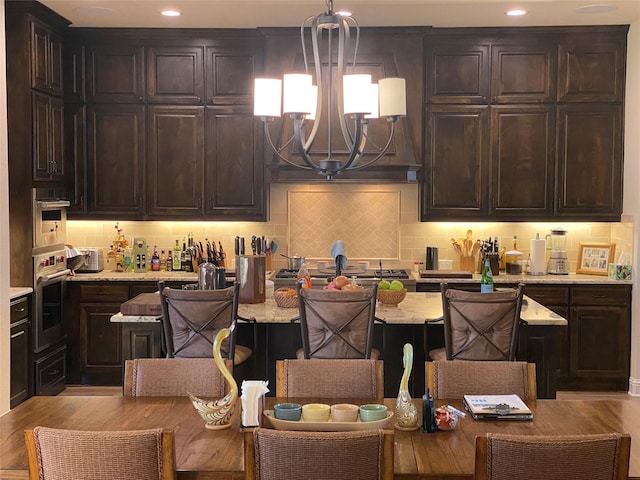 kitchen featuring pendant lighting, backsplash, an inviting chandelier, and appliances with stainless steel finishes