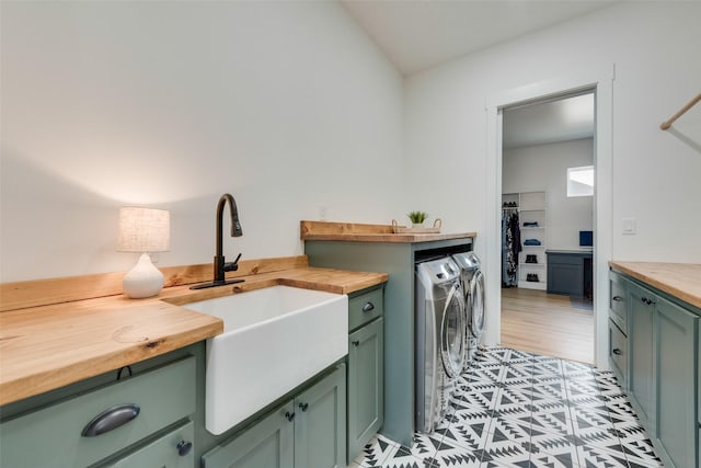 clothes washing area featuring cabinets, separate washer and dryer, and sink