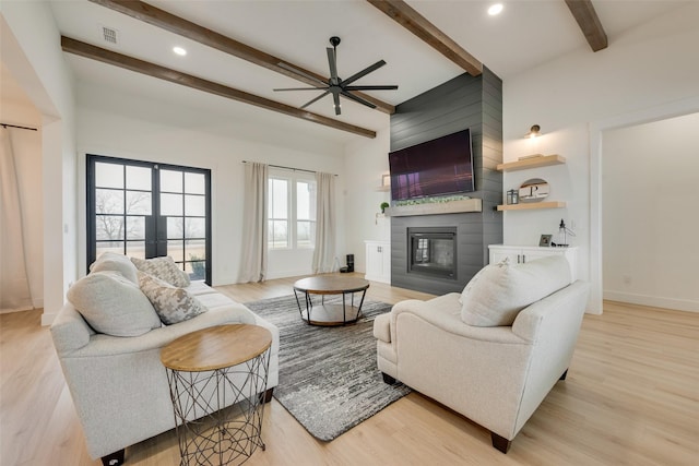 living room with french doors, a large fireplace, beam ceiling, and light wood-type flooring