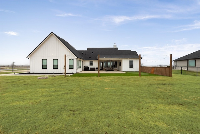 rear view of house featuring a yard and a patio