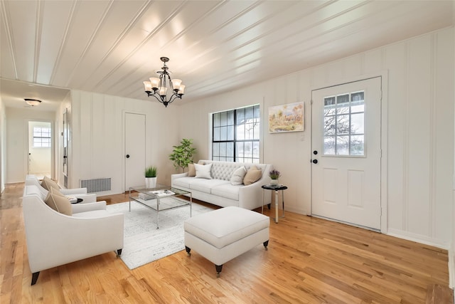 living room with wood ceiling, a chandelier, and light wood-type flooring