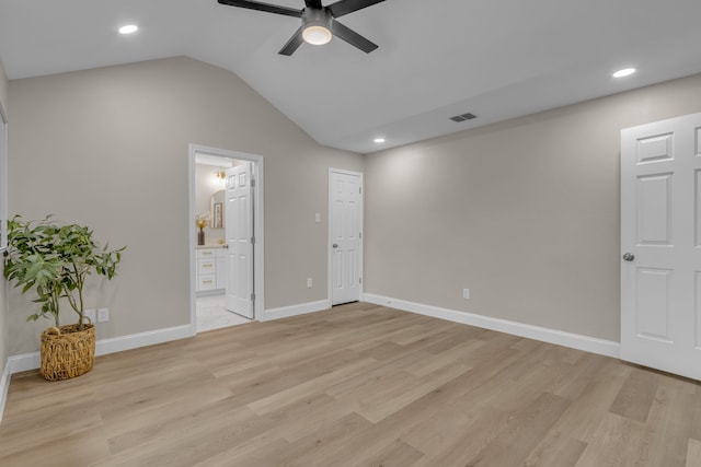 unfurnished bedroom with ceiling fan, connected bathroom, vaulted ceiling, and light wood-type flooring