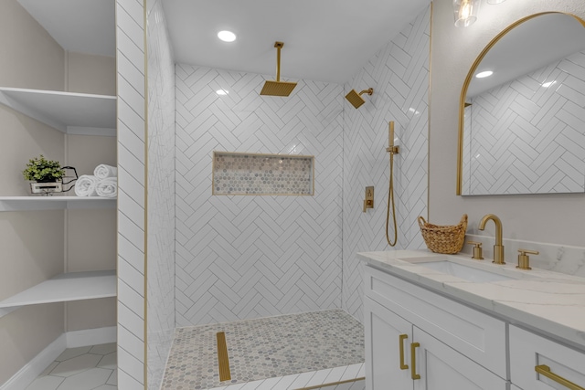 bathroom with vanity, a tile shower, and tile patterned floors