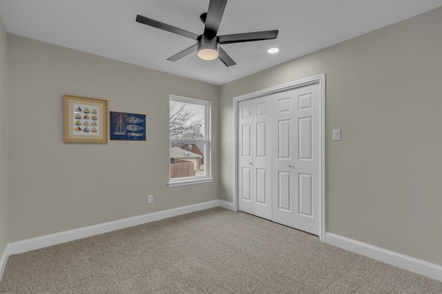 unfurnished bedroom with light colored carpet, a closet, and ceiling fan