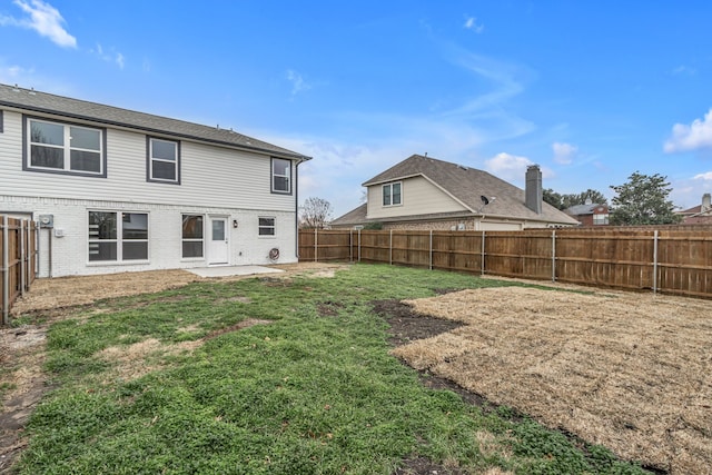 rear view of property with a yard and a patio area