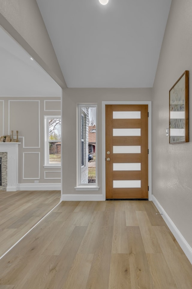 entryway with lofted ceiling and light wood-type flooring