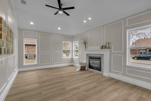 unfurnished living room featuring ceiling fan, a healthy amount of sunlight, and light hardwood / wood-style flooring