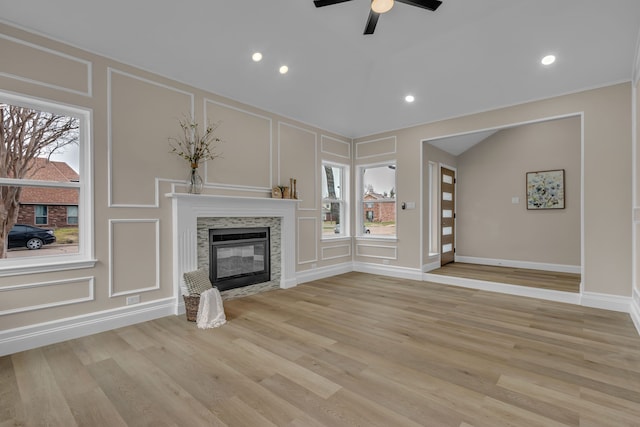 unfurnished living room with vaulted ceiling, ceiling fan, and light wood-type flooring