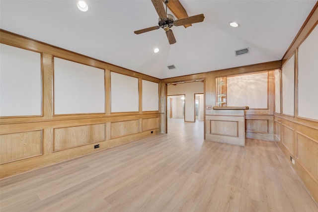 spare room with ceiling fan, vaulted ceiling, and light hardwood / wood-style flooring