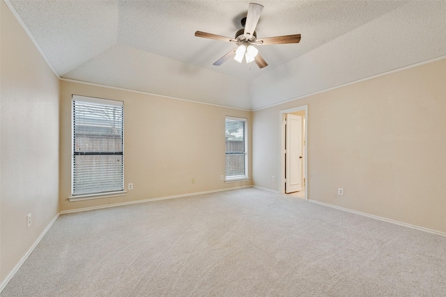 carpeted empty room with ornamental molding, lofted ceiling, a healthy amount of sunlight, and ceiling fan