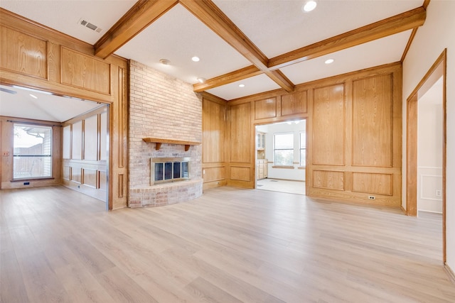 unfurnished living room featuring coffered ceiling, a brick fireplace, beam ceiling, and light hardwood / wood-style flooring