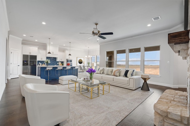 living room featuring ornamental molding, dark hardwood / wood-style floors, and ceiling fan with notable chandelier