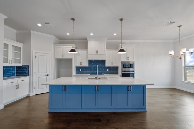 kitchen featuring stainless steel appliances, an island with sink, and white cabinets