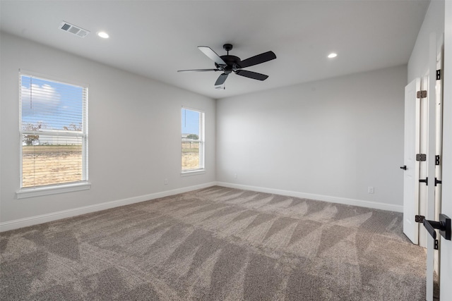 unfurnished room with ceiling fan and carpet