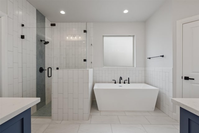 bathroom with vanity, independent shower and bath, and tile walls