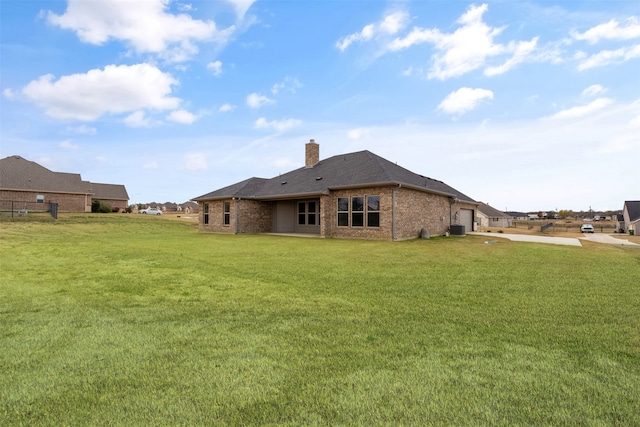 rear view of property with cooling unit and a lawn