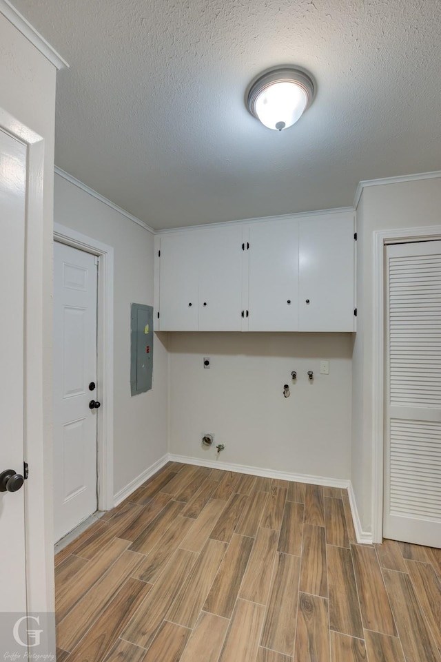 washroom featuring gas dryer hookup, wood finish floors, electric panel, cabinet space, and electric dryer hookup