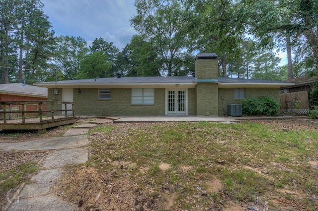 rear view of property featuring central air condition unit, brick siding, a patio area, and french doors