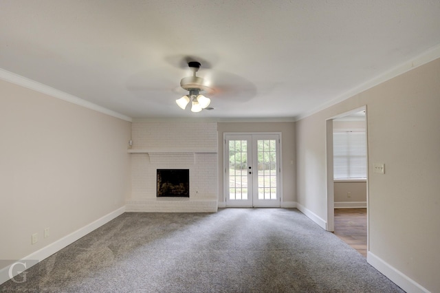 unfurnished living room with ornamental molding, carpet flooring, a fireplace, and baseboards