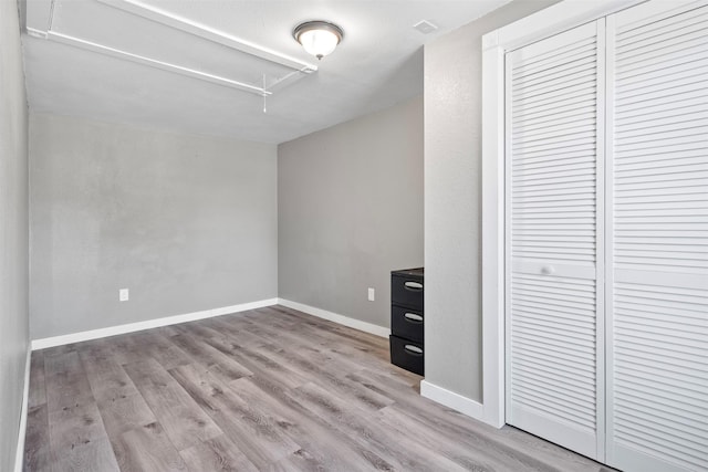 unfurnished bedroom with light hardwood / wood-style floors and a closet