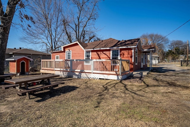 exterior space featuring a storage shed, a deck, and a front lawn