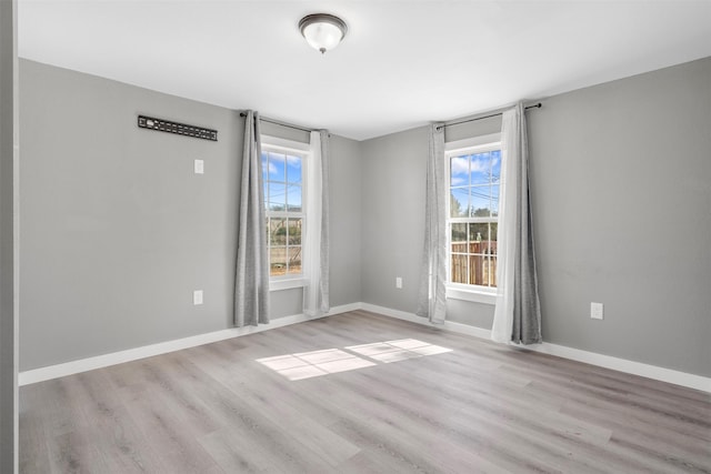 unfurnished room featuring plenty of natural light and light hardwood / wood-style floors