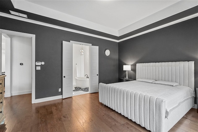 bedroom with ensuite bathroom and dark wood-type flooring