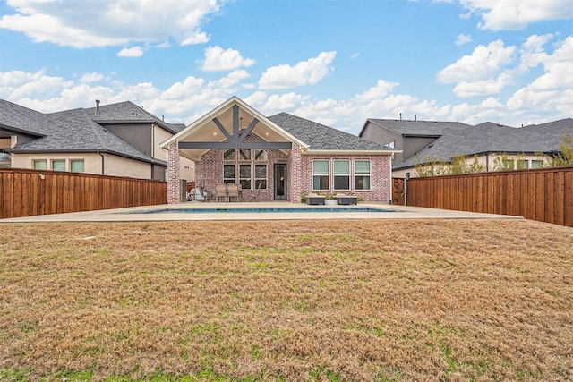 back of property featuring a pool, a patio area, and a lawn