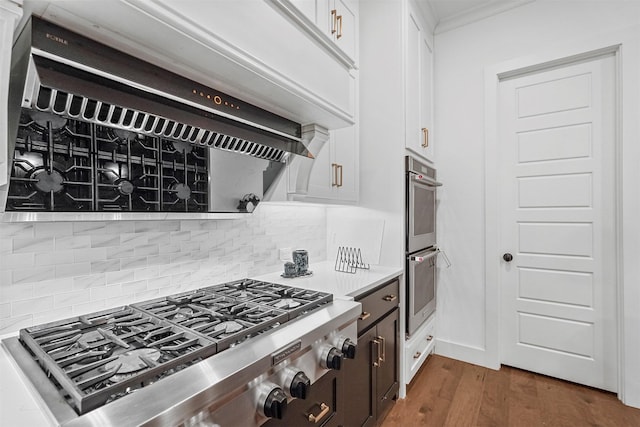 kitchen with white cabinetry, appliances with stainless steel finishes, dark wood-type flooring, and decorative backsplash