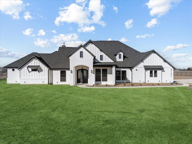 modern farmhouse with a front yard and french doors