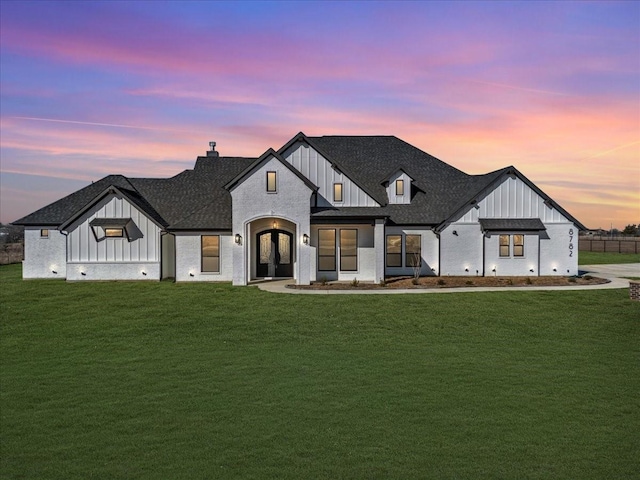 modern farmhouse style home featuring french doors and a yard