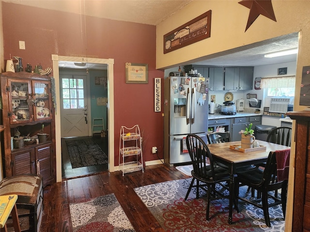 dining room featuring dark hardwood / wood-style flooring, cooling unit, and a textured ceiling