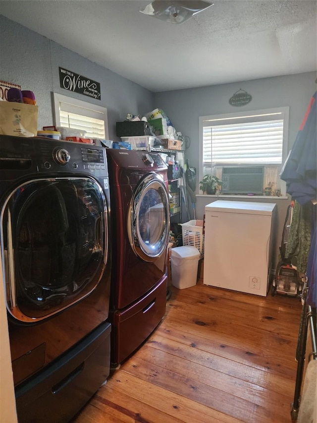 washroom featuring cooling unit, hardwood / wood-style floors, and washer and dryer