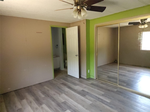 unfurnished bedroom with ceiling fan, a closet, and light hardwood / wood-style flooring